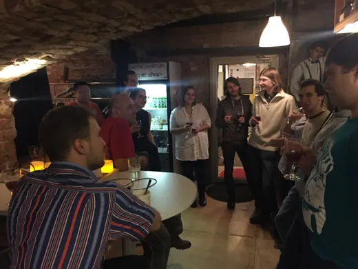 People standing and talking, a man in a striped shirt in the foreground