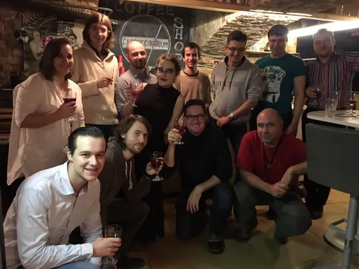 A group photograph, some crouching at the front, glasses raised