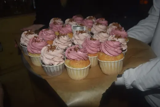A tray of cupcakes with pink icing