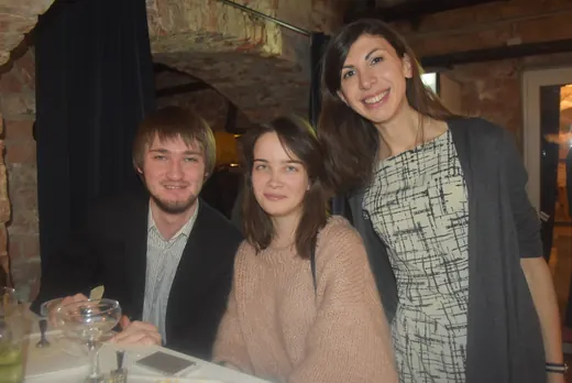 Three people at a table, smiling