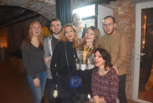 Six people posing together in the cellar