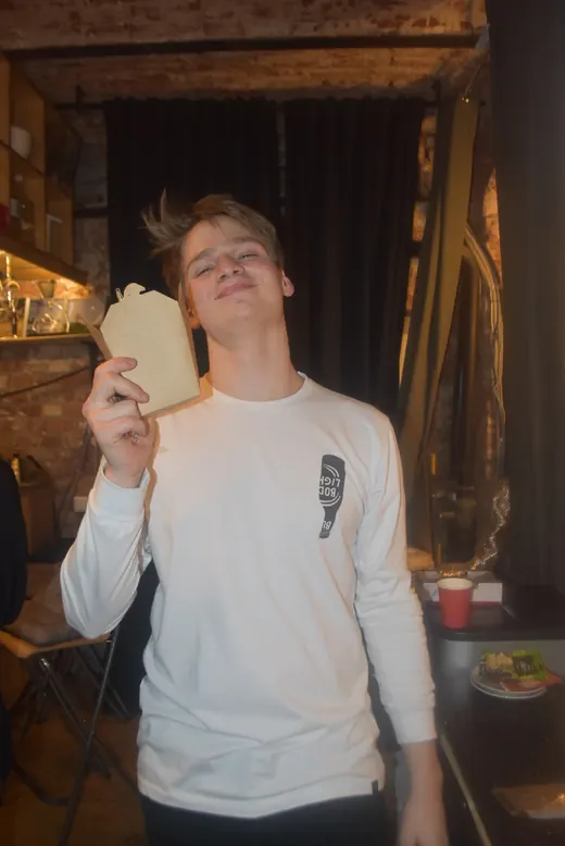 A man laughing and holding up a card