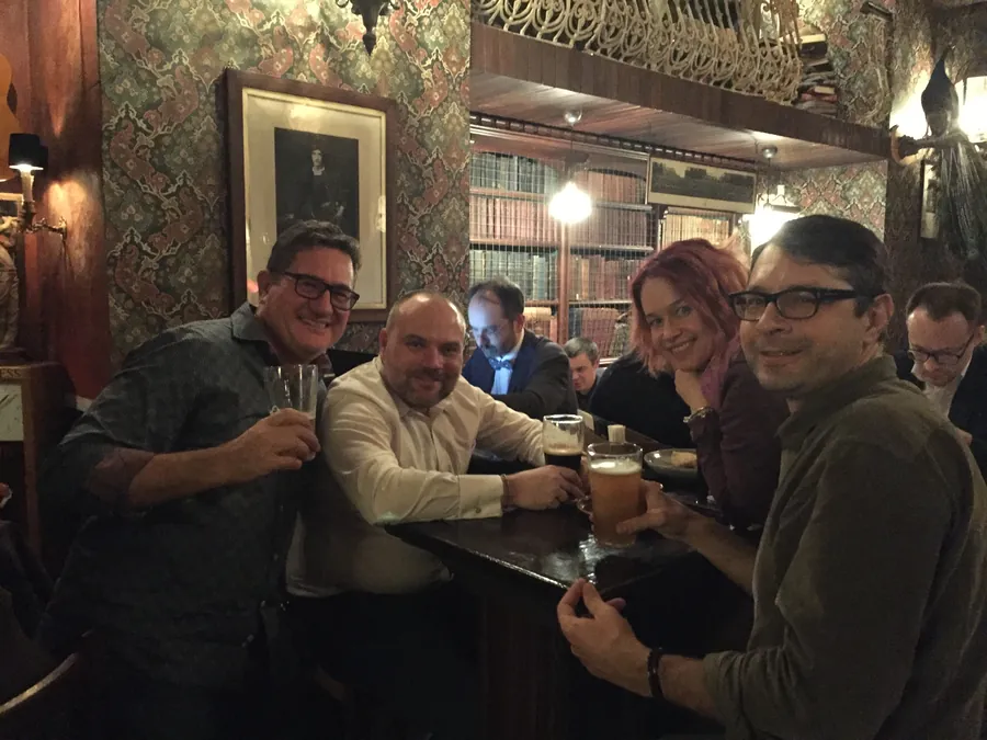 A table of friends in the pub next door, glasses raised