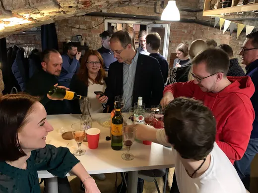A table crowded with people and bottles