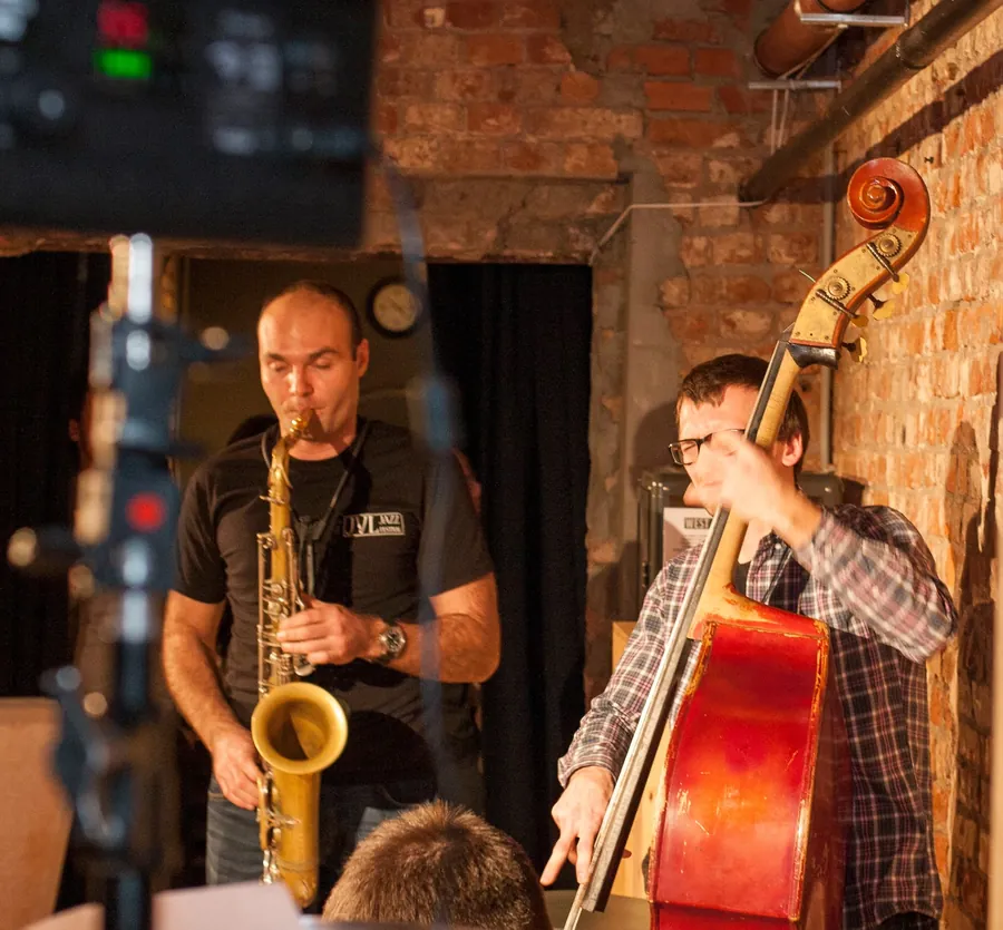 A saxophonist and a double bassist playing in the brick room