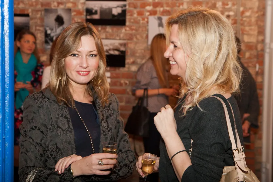 Two women laughing together, a glass raised