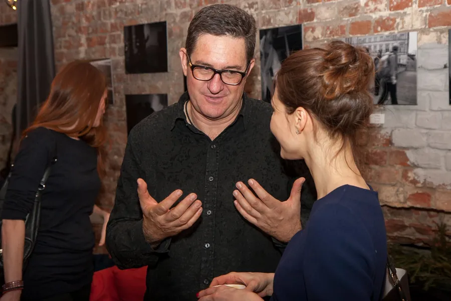 A man explaining something with his hands to two listeners