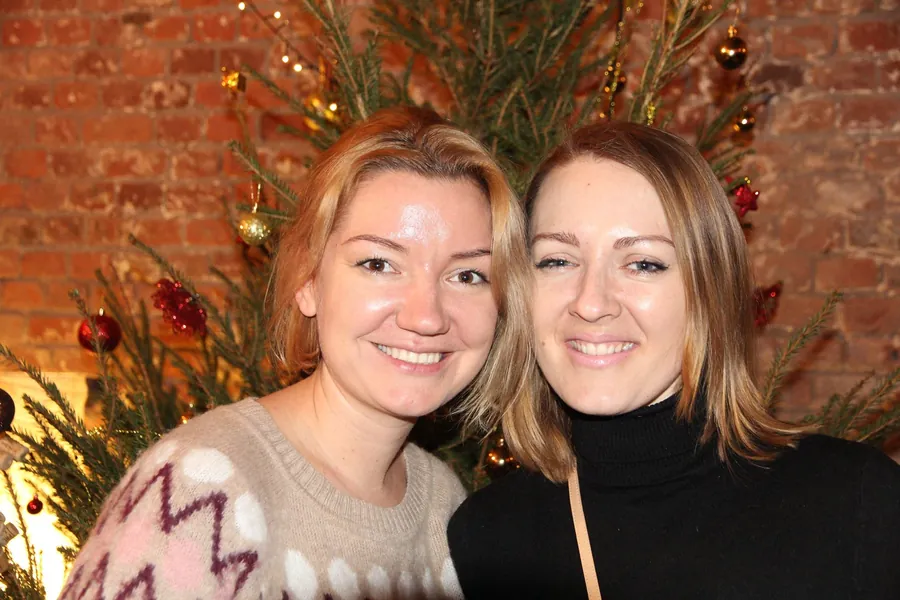 Two women smiling by the Christmas tree