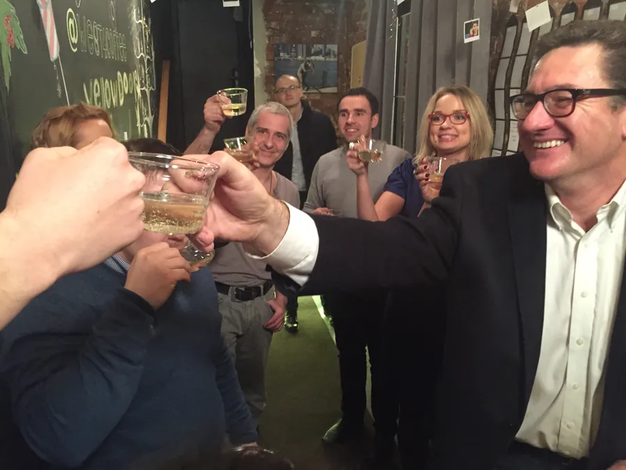 A toast: glasses raised together over a table on the opening night
