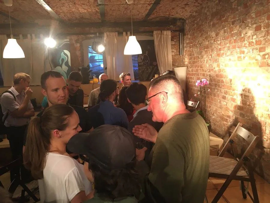Two men talking, one leaning in to hear