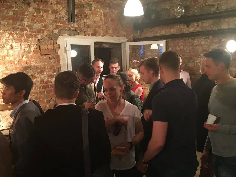 An evening crowd talking in small groups