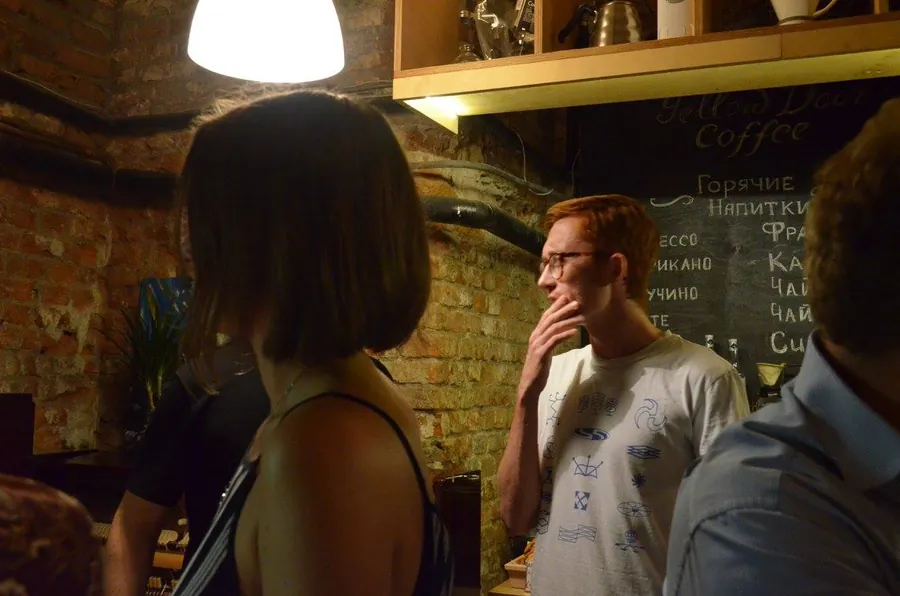 A woman with a bob listening to a man in a white t-shirt