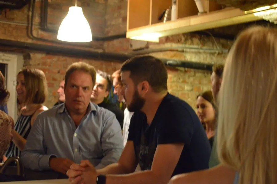 Two men in intent conversation, one in a blue shirt