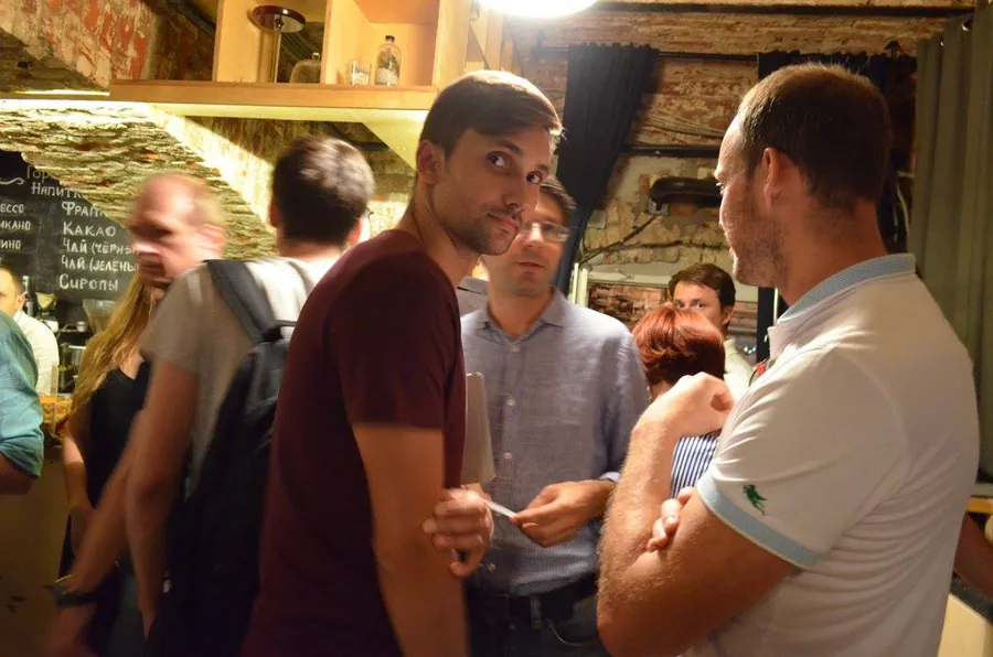 A man turning to smile at the camera from the middle of the crowd