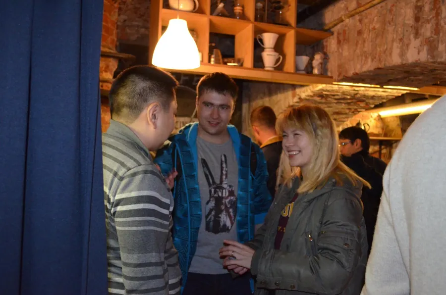 Three people talking, a woman with blonde hair listening