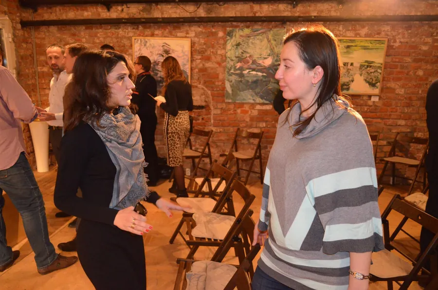 Two women talking by the folding chairs