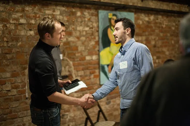 Two men shaking hands, name tags on