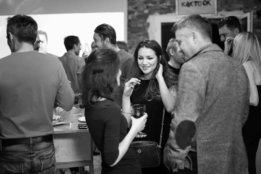 A crowd with wine glasses, black and white