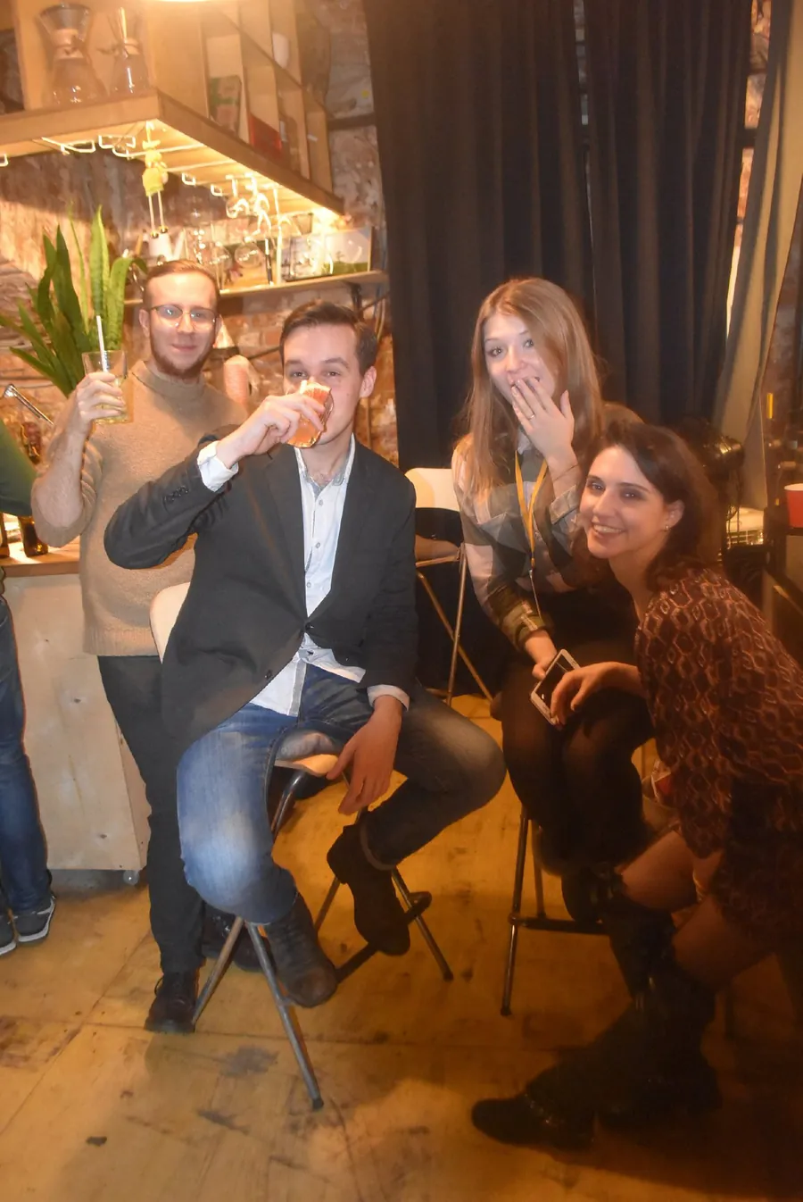 Three people raising glasses, a woman laughing