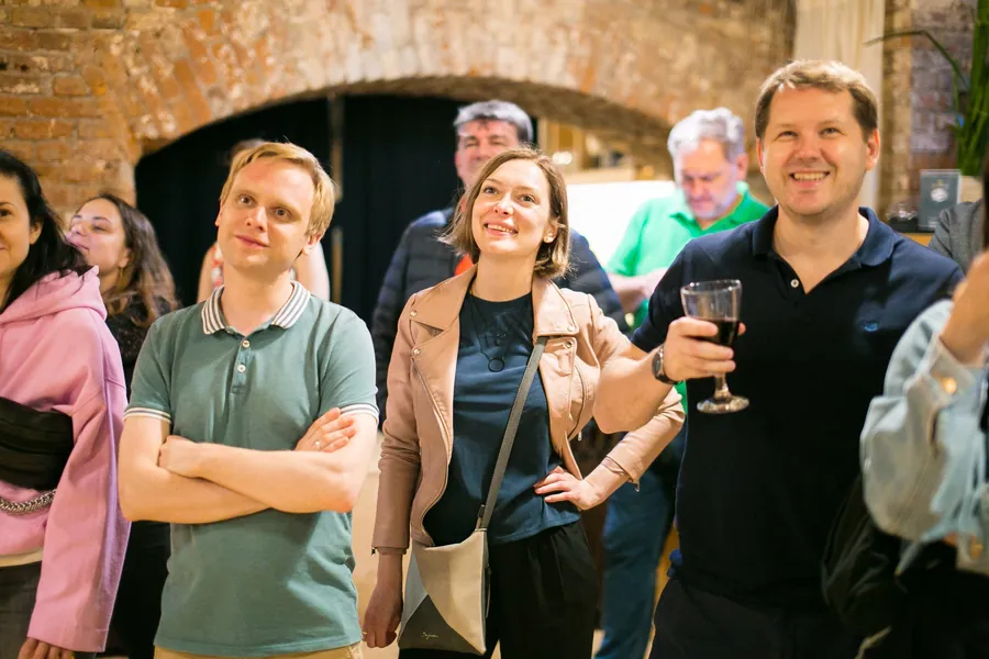 Friends with glasses in hand, laughing at something said