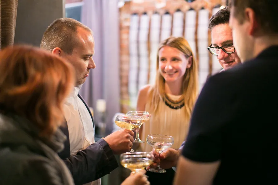 Two coupes meeting in a toast across the bar