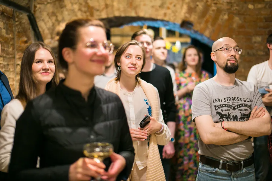 Guests laughing together, one raising a coupe