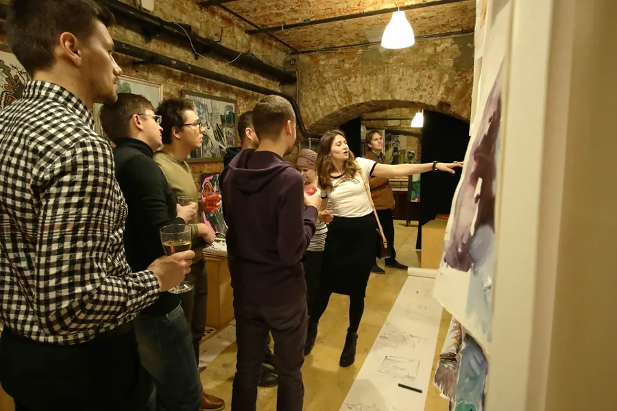 Mingling among the paintings, glasses in hand