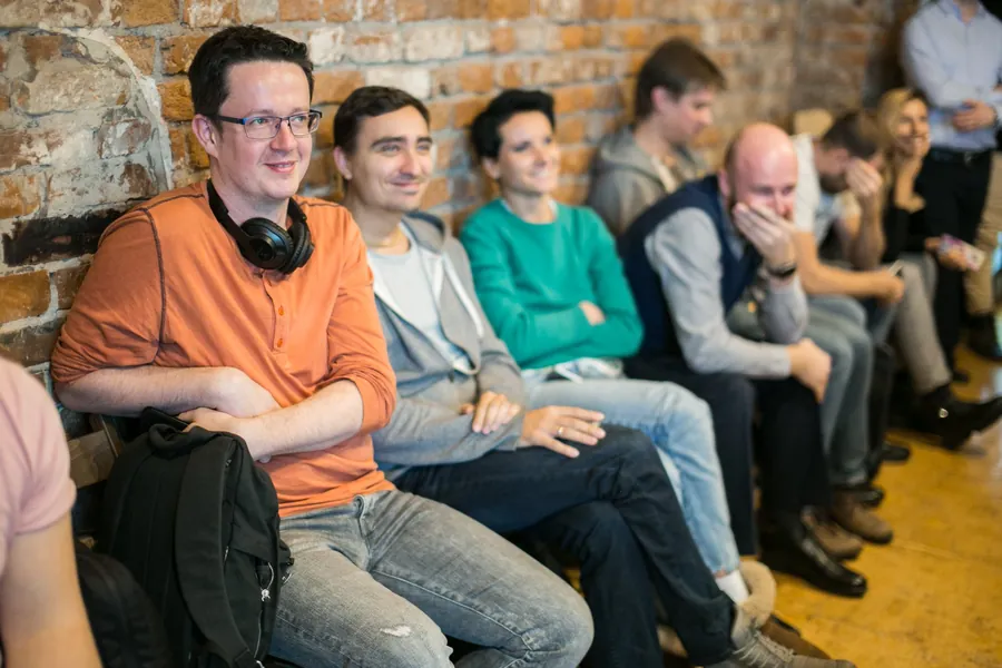 Men on the sofa laughing, one in orange